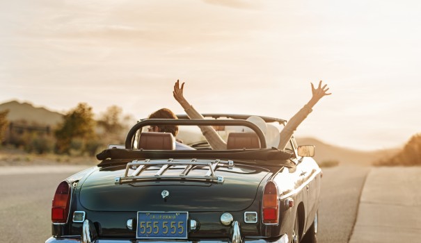 two people riding in a convertible car